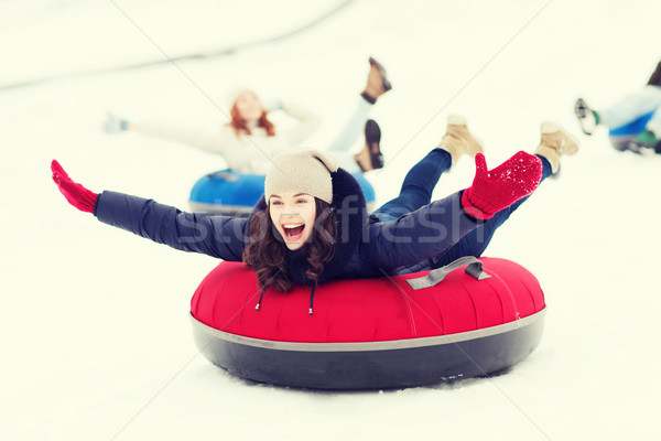 group of happy friends sliding down on snow tubes Stock photo © dolgachov