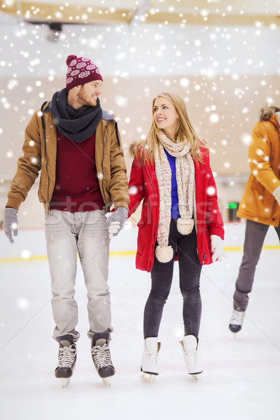 Stock photo: happy couple holding hands on skating rink