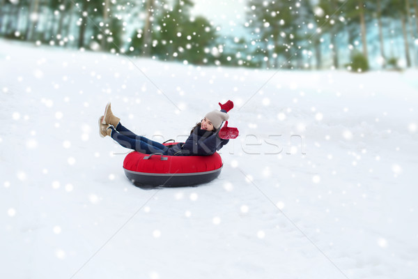 happy teenage girl sliding down on snow tube Stock photo © dolgachov