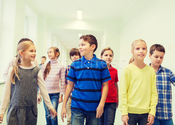 group of smiling school kids walking in corridor Stock photo © dolgachov