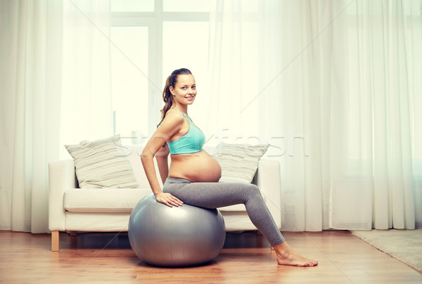 happy pregnant woman exercising on fitball at home Stock photo © dolgachov