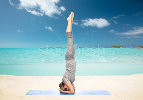 woman making yoga in headstand pose on beach  Stock photo © dolgachov