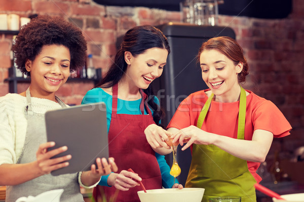 happy women with tablet pc in kitchen Stock photo © dolgachov