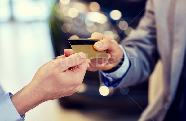 Stock photo: customer giving credit card to car dealer in salon