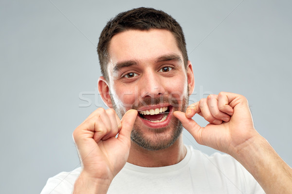Mann Zahnseide Reinigung Zähne grau Gesundheitspflege Stock foto © dolgachov