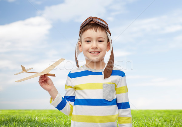 happy little boy in aviator hat with airplane Stock photo © dolgachov