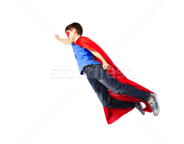 boy in red superhero cape and mask flying on air Stock photo © dolgachov