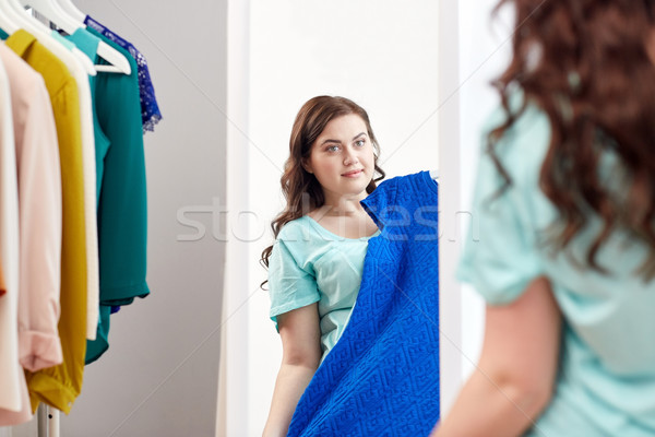 Stock photo: happy plus size woman with dress at mirror