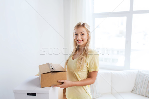 smiling young woman with cardboard box at home Stock photo © dolgachov