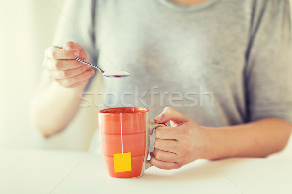 close up of woman adding sugar to tea cup Stock photo © dolgachov