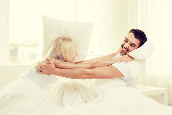 Heureux couple bataille d'oreillers lit maison personnes [[stock_photo]] © dolgachov