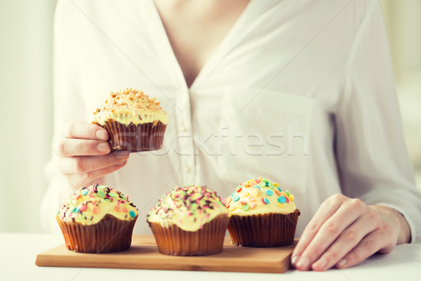 close up of woman with glazed cupcakes or muffins Stock photo © dolgachov