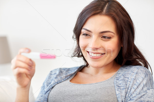 快樂 女子 看 家 妊娠試驗 懷孕 商業照片 © dolgachov