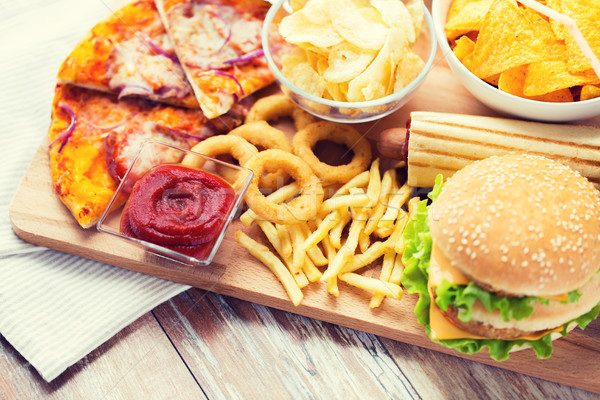 Stock photo: close up of fast food snacks on wooden table