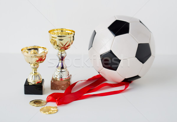 close up of football ball, golden cups and medals Stock photo © dolgachov