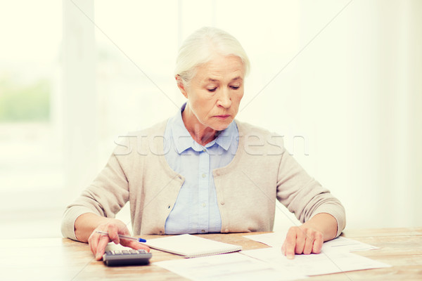 senior woman with papers and calculator at home Stock photo © dolgachov