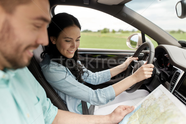 happy man and woman with road map driving in car Stock photo © dolgachov