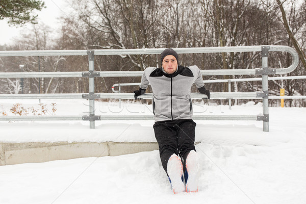 sports man doing triceps dips at fence in winter Stock photo © dolgachov