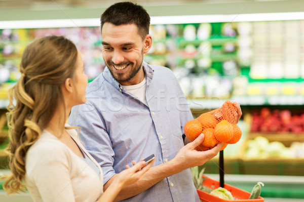 happy couple buying oranges at grocery store Stock photo © dolgachov