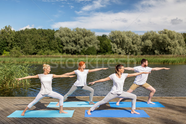 group of people making yoga exercises outdoors Stock photo © dolgachov