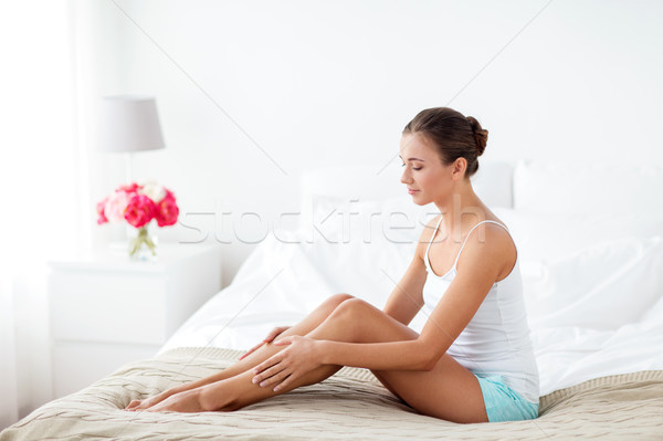 beautiful woman with bare legs on bed at home Stock photo © dolgachov