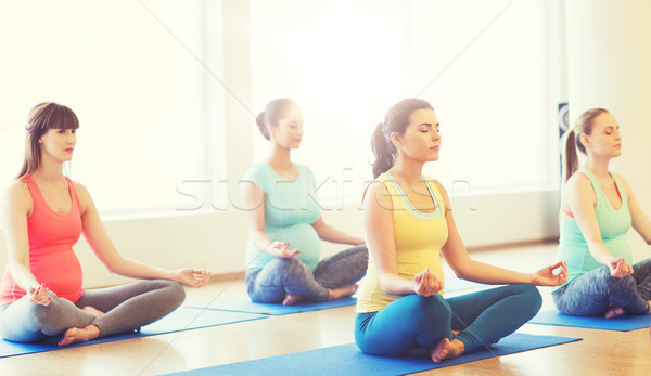 happy pregnant women exercising yoga in gym Stock photo © dolgachov