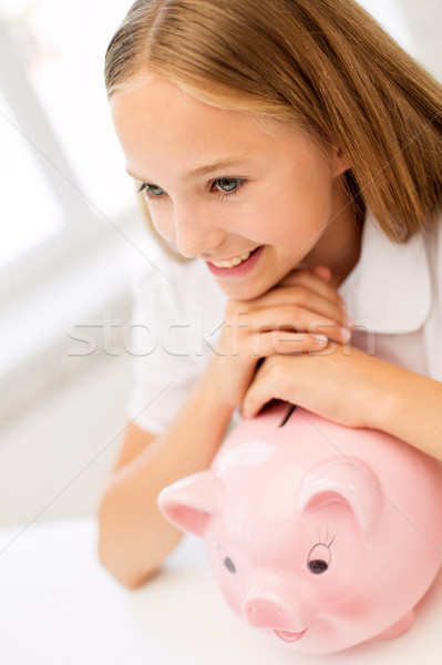 happy girl with piggy bank at home Stock photo © dolgachov