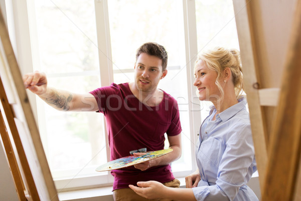 artists with palette and easel at art school Stock photo © dolgachov