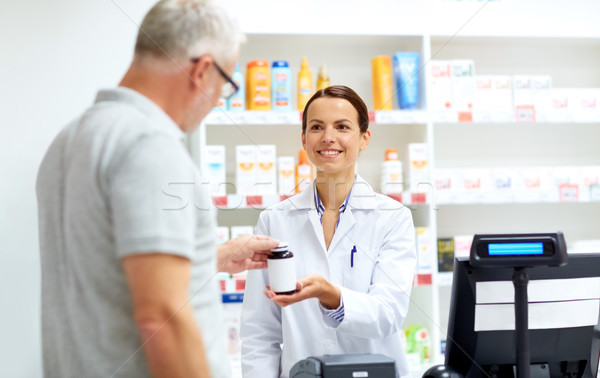 apothecary and senior customer at pharmacy Stock photo © dolgachov