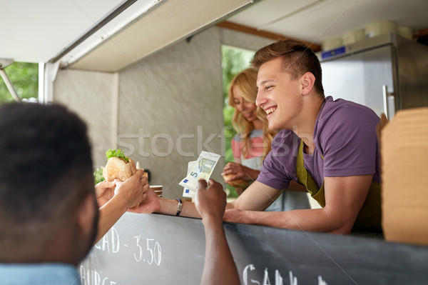 happy salesman selling hamburgers at food truck Stock photo © dolgachov