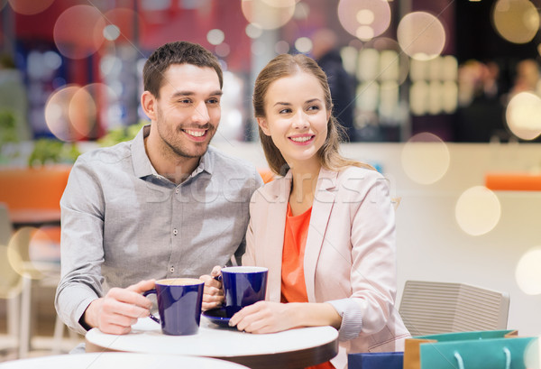 Stock photo: happy couple with shopping bags drinking coffee