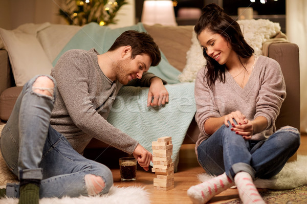 happy couple playing block-stacking game at home Stock photo © dolgachov