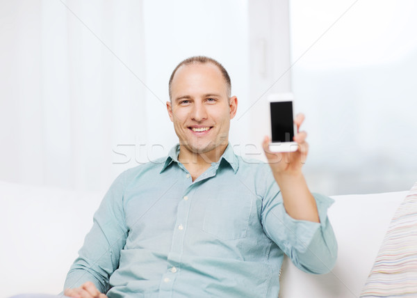 smiling man with smartphone at home Stock photo © dolgachov