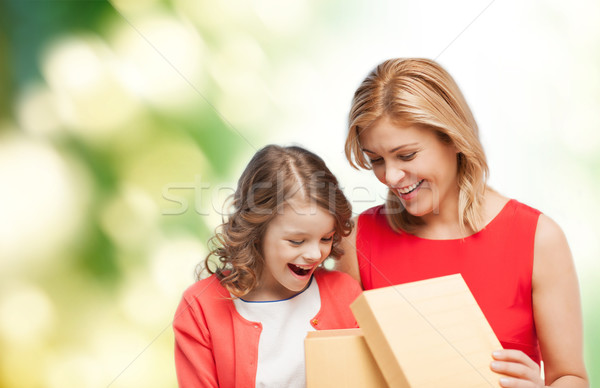 smiling mother and daughter opening gift box Stock photo © dolgachov