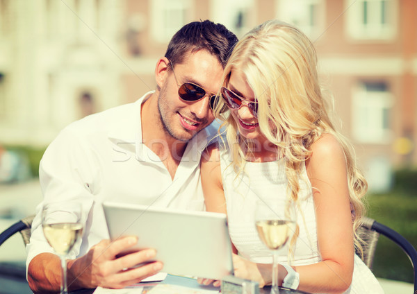 Stock photo: couple looking at tablet pc in cafe