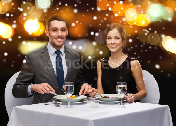 smiling couple eating main course at restaurant Stock photo © dolgachov