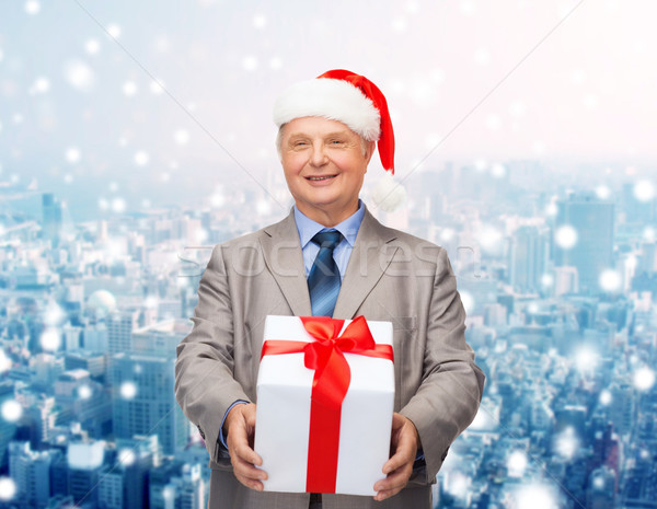 smiling man in suit and santa helper hat with gift Stock photo © dolgachov