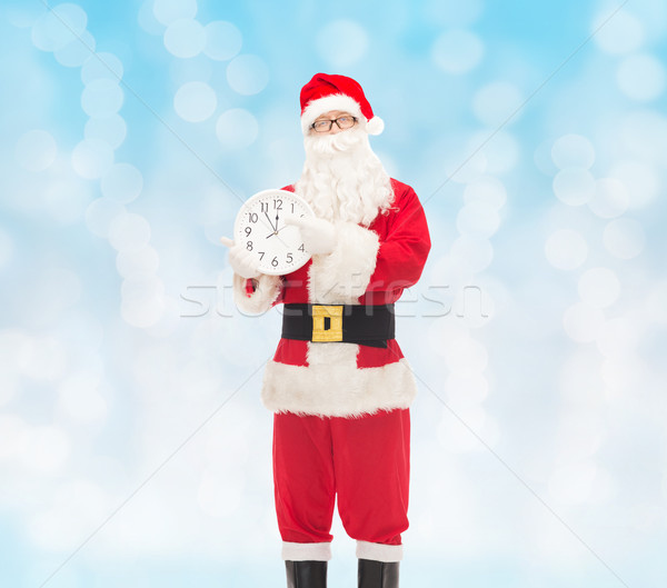 man in costume of santa claus with clock Stock photo © dolgachov