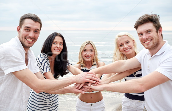 smiling friends putting hands on top of each other Stock photo © dolgachov