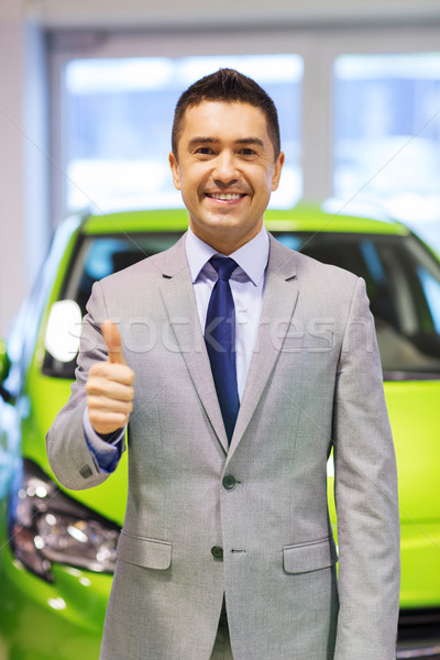man showing thumbs up at auto show or car salon Stock photo © dolgachov