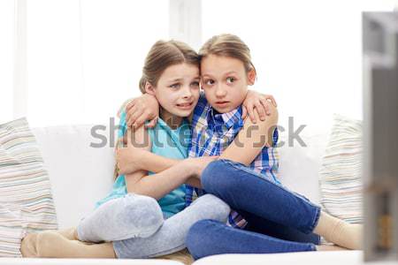 scared little girls watching horror on tv at home Stock photo © dolgachov