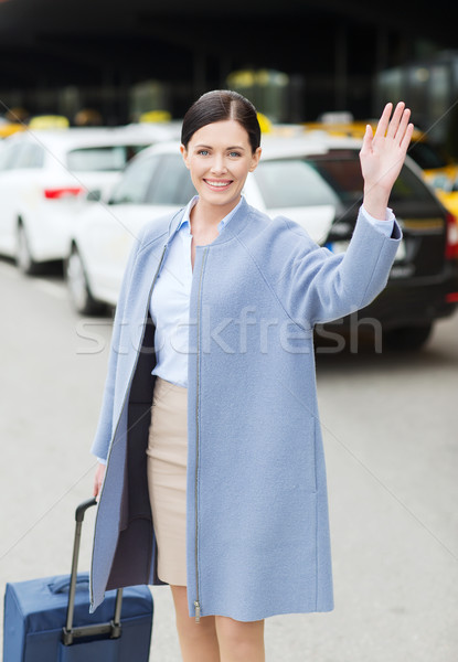 smiling young woman with travel bag waving hand Stock photo © dolgachov