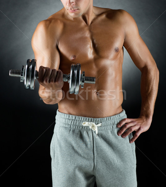 young man with dumbbell Stock photo © dolgachov