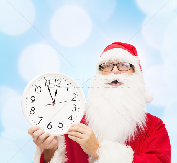 man in costume of santa claus with clock Stock photo © dolgachov