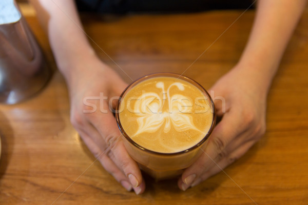 close up of hands with latte art in coffee cup Stock photo © dolgachov