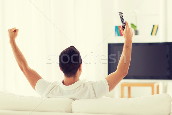 man watching tv and supporting team at home Stock photo © dolgachov