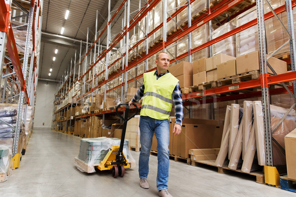 man carrying loader with goods at warehouse Stock photo © dolgachov