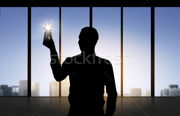 silhouette of businessman holding light bulb Stock photo © dolgachov
