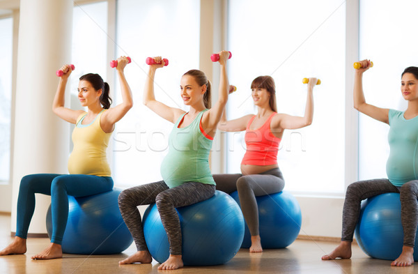 happy pregnant women exercising on fitball in gym Stock photo © dolgachov