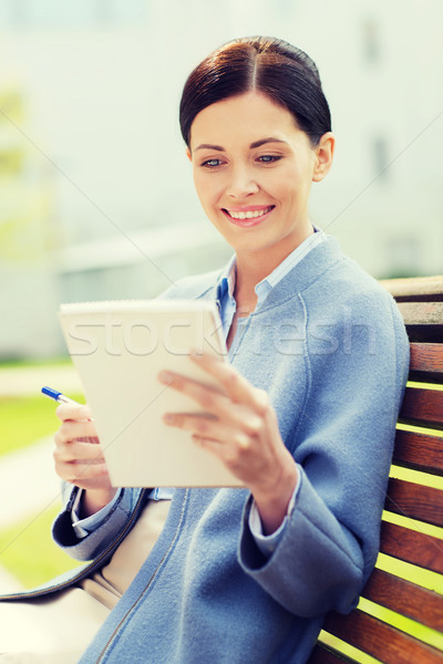 Stock photo: businesswoman reading notes in notepad outdoors